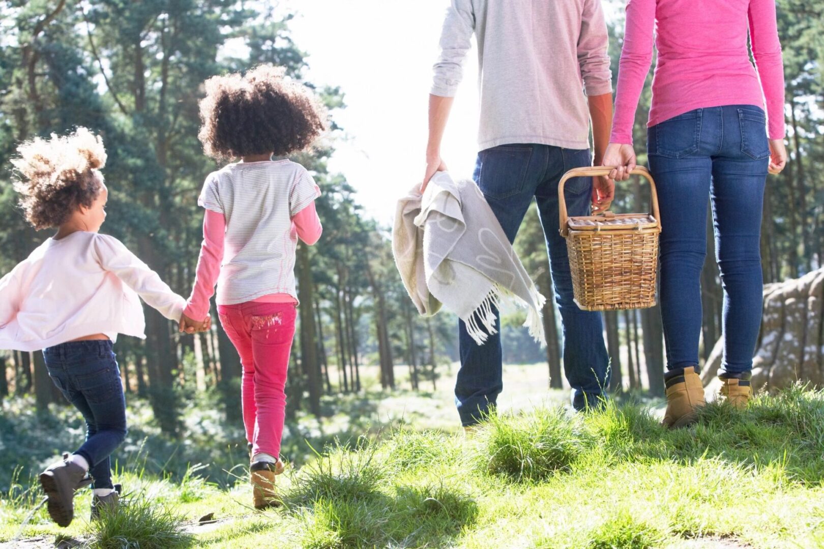 A group of people walking through the grass holding hands.