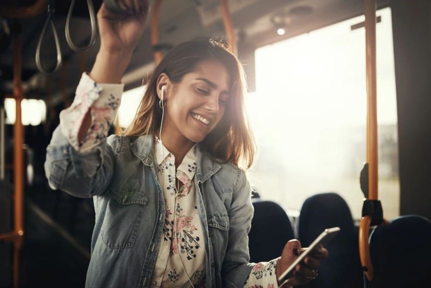 A woman holding her phone up in the air.